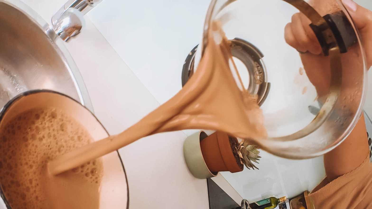Freshly made Chai Tea is being poured into a tea mug.